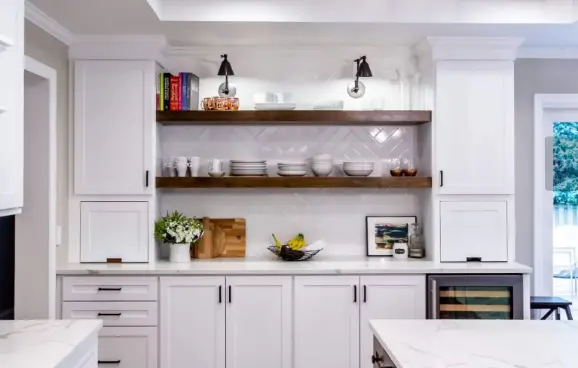 Kitchen painted all white with colorful books, flowers and pictures